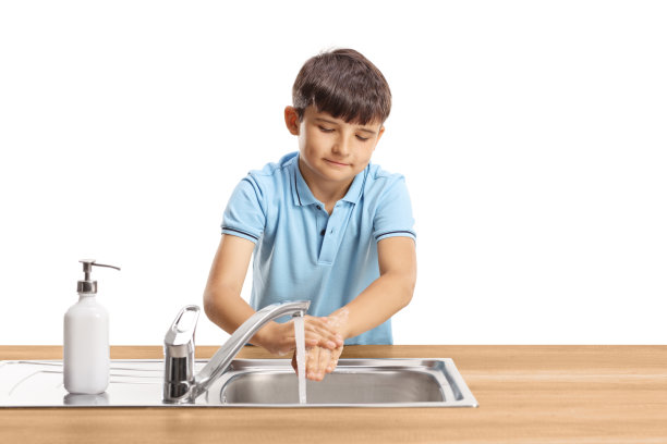 一个孩子在不锈钢水槽里洗手的照片图片下载