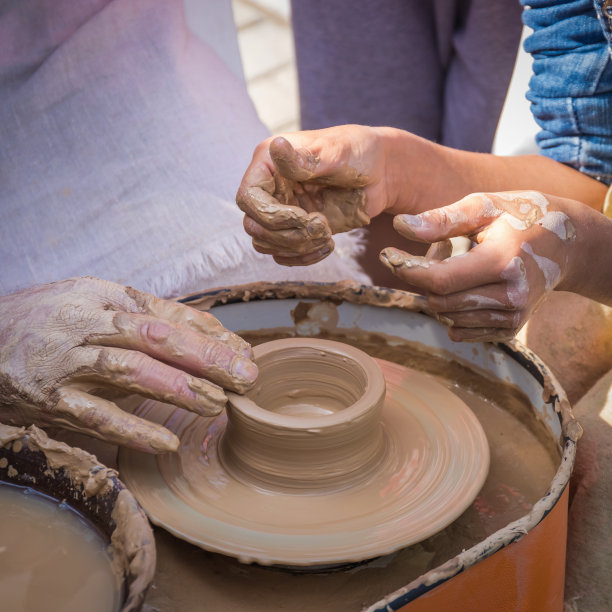 陶艺大师的双手向学生揭示了制作陶土制品的秘密。图片下载