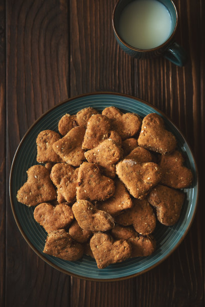 俯视图自制全麦饼干燕麦，葡萄干，坚果，种子和牛奶在棕色的乡村木制背景。健康饮食的概念。本空间图片下载