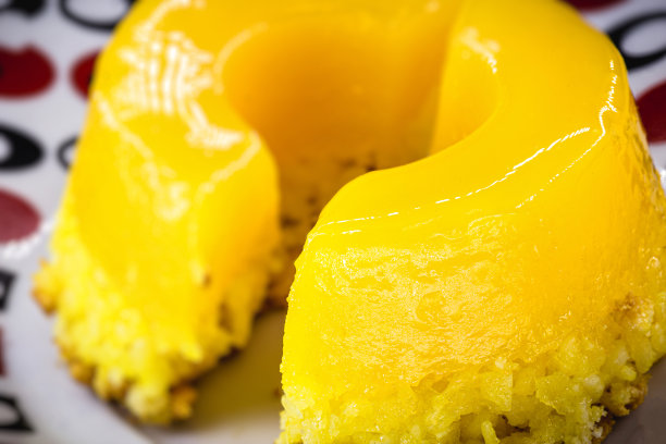 一块Quindim布丁，用巴西鸡蛋切成的小布丁，加糖和磨碎的椰子。巴西美食的微距或特写照片图片下载