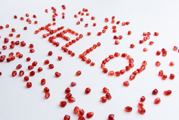 白色背景的石榴籽上的“你好”字图片下载