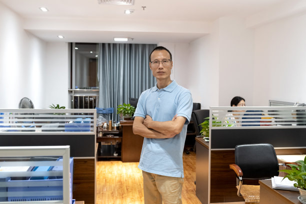 亚洲男性白领在办公室里看着照相机。图片下载