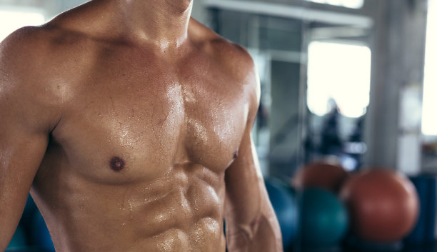 近胸肌肉裸露的男人在健身锻炼后出汗。运动型的人有腹肌和二头肌。性感的身体来自健康的运动男性健美。本空间图片下载