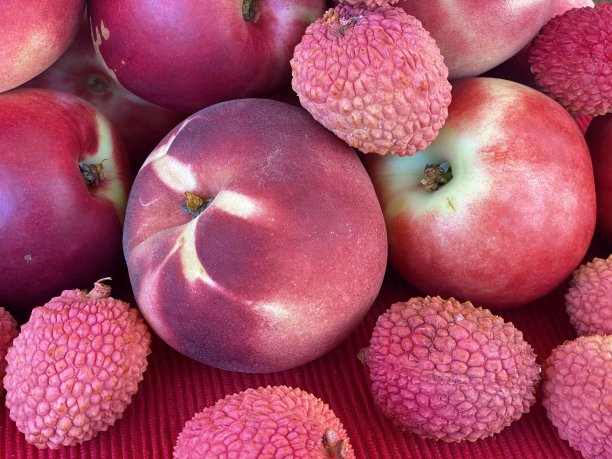 混合水果：红色布餐巾上的新鲜红桃、油桃和荔枝图片下载