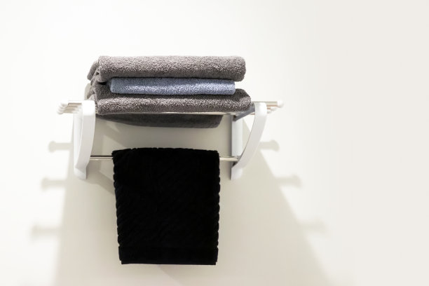 酒店浴室的毛巾架上有干净的黑色毛巾，白色墙壁。现代最小的风格图片下载