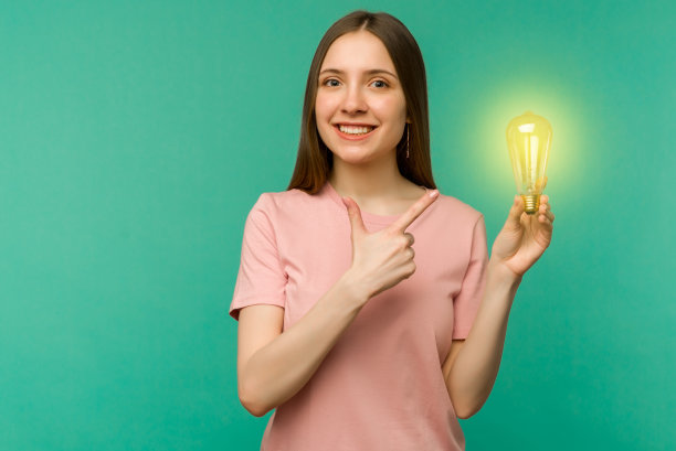 可爱的女学生指着她手中的灯孤立的背景。图片下载