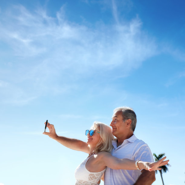 中年男人和女人夫妇在阳光明媚的蓝天下自拍图片下载