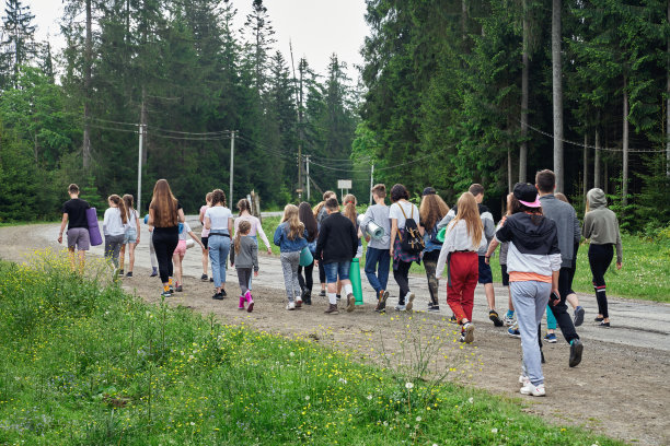 青少年走过潮湿的云杉森林道路。图片下载
