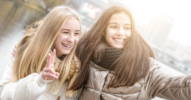 十几岁的女孩们在河边自拍，面带微笑图片下载