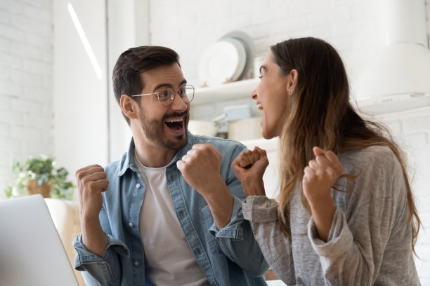 一对喜出望外的夫妇在笔记本电脑上中奖图片下载