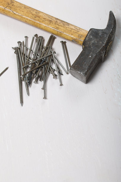 一把旧锤子和一把钉子。在白色背景上。图片下载
