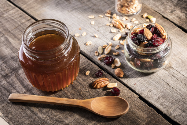 蜂蜜滴进玻璃瓶。图片下载