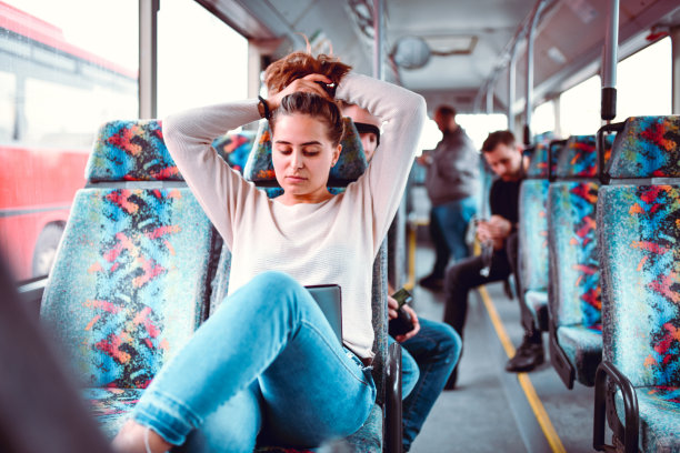 女性看发髻教程在数字平板电脑上和尝试它在公交车上图片下载