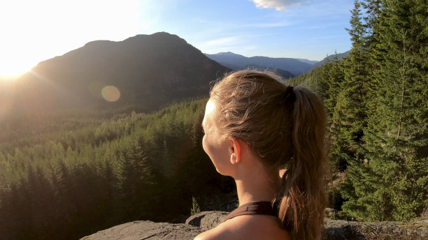 年轻女子在石板上休息，望向别处图片下载