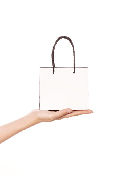 女人手里拿着一个购物袋孤立在白色。图片下载