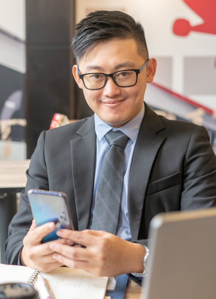 年轻的商人拿着智能手机，看着镜头图片下载