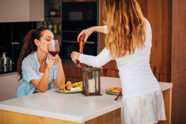 两个女人在家里享用开胃菜和酒的照片图片下载