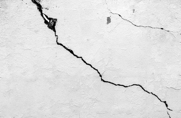 黑白概念的素白灰泥砖墙与裂缝为背景，图案和纹理为背景。混凝土表面稍微粗糙。随机无缝墙体图案图片下载