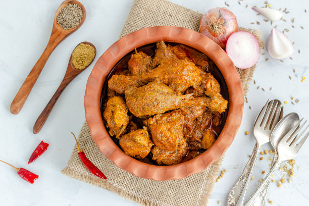 印度风味辣咖喱鸡从上到下的照片，鸡肉配洋葱，红辣椒，柠檬和香料图片下载