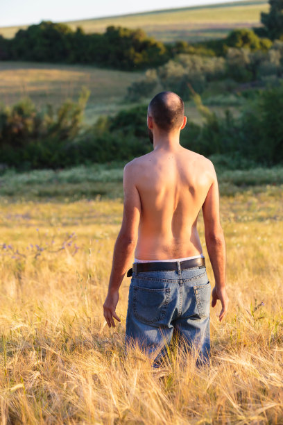 赤裸上身的年轻人在阳光明媚的田野里图片下载