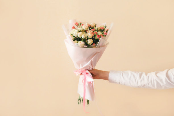 手在白衬衫与玫瑰花束近米色背景。图片下载