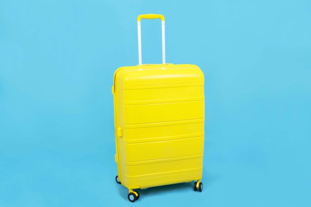 黄色行李箱或行李孤立在蓝色背景下，旅行概念图片下载