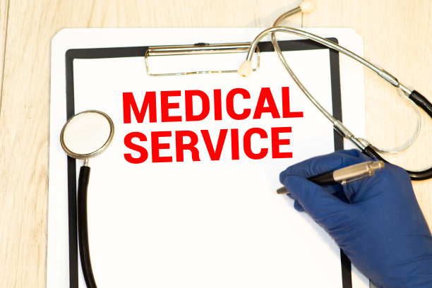 文本医疗服务写在一个医疗笔记本上。黄色的桌子上有一个听诊器和一支钢笔。医学与健康理念图片下载