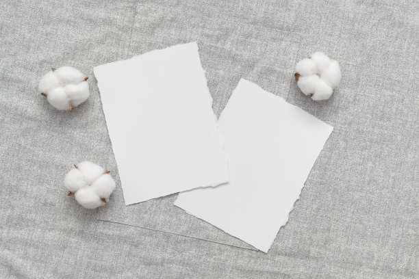 女性婚礼，生日桌面模型。空白贺卡或请柬在亚麻织物上与棉花花。简约的文具。俯视图，平放，复制空间。图片下载