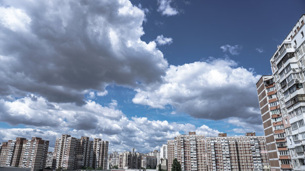 公寓大楼在美丽的云彩的背景下。高层建筑是用人们居住的面板结构建造的。库存图片背景图片下载