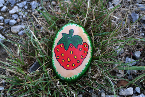 人行道上有一块涂了漆的登山石，供路人观看图片下载