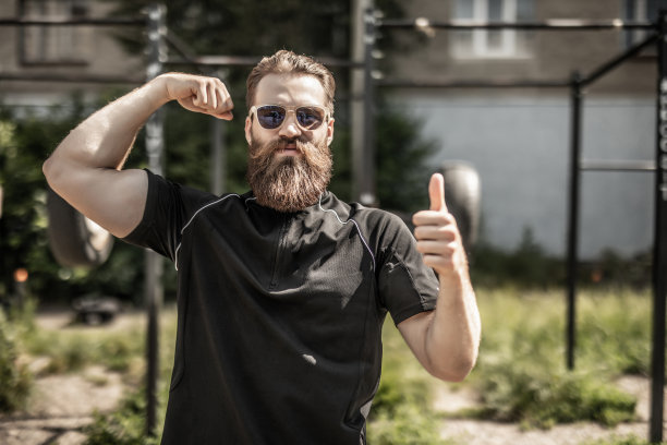年轻的大胡子男子，对户外锻炼竖起大拇指图片下载