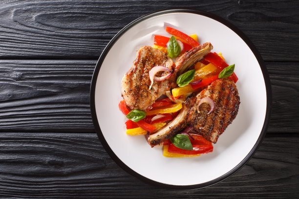 美味的烤猪排配上甜椒、洋葱和罗勒。水平的俯视图图片下载