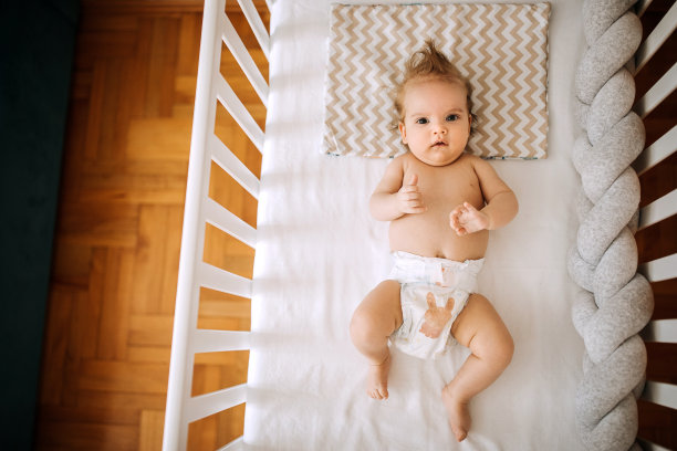 可爱的小男孩躺在他的婴儿床里图片下载