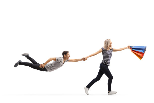 女人购物狂跑和拉她的男朋友孤立在白色背景图片下载