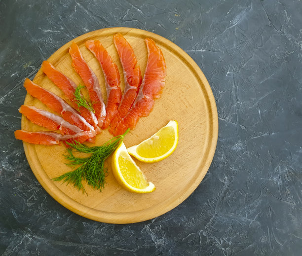 红色的咸鱼片，混凝土背景上有柠檬图片下载