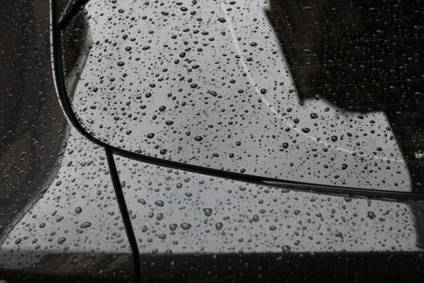 在布拉格一条名为Biskupcova的街道上，一辆停在那里的汽车被雨水淋湿了。图片下载