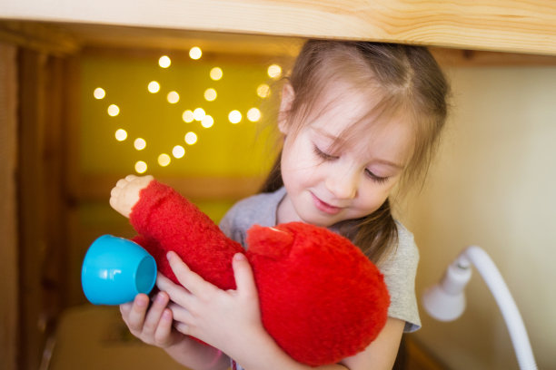 孩子的游戏。女孩在家里玩玩具。有夜灯的房子图片下载