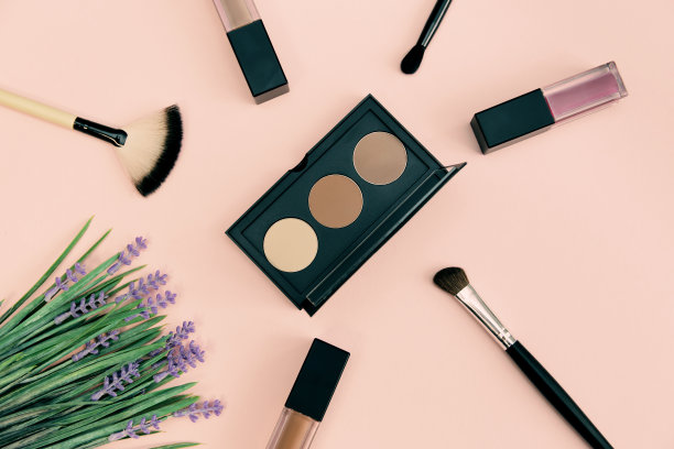 用化妆刷在彩色背景上装饰化妆品。图片下载