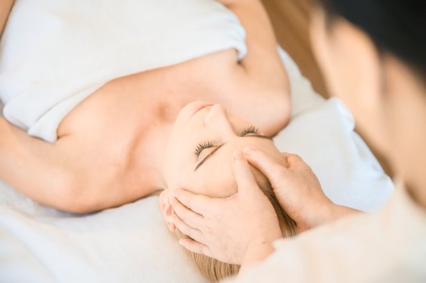 在水疗沙龙接受头部和面部按摩的美丽女人。身体保健的概念和传统泰式按摩放松图片下载