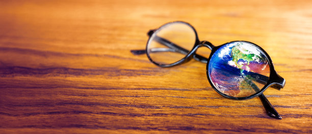 世界反射在圆形眼镜上的木材在柔和的照明图片下载