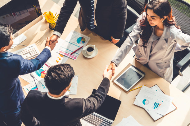 团队商务人员在会议桌上握手图片下载