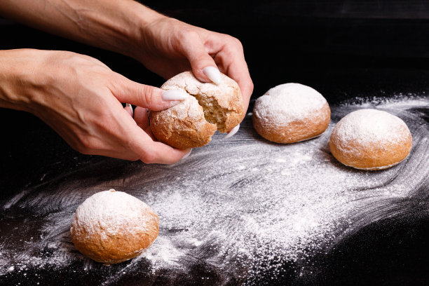 自制的糕点。白面包用手分开。烘焙的照片。图片下载