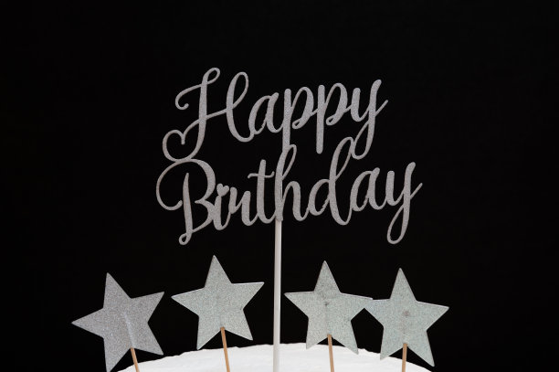 用星星形状的银色字母写的生日快乐。孤立在黑色背景上图片下载