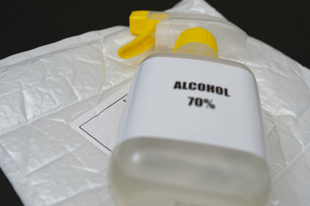 气泡膜衬垫信封上70%酒精喷雾，带有邮寄标签。 黑色背景隔离。 选择性聚焦图片下载