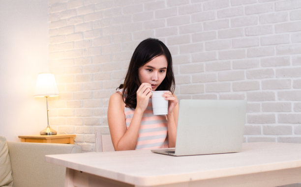 肖像亚洲女人忙着吃美味的热辣方便面工作看着平板电脑图片下载