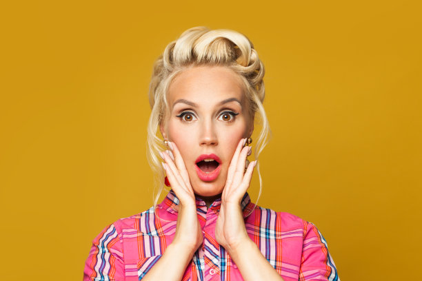 令人惊讶的Pinup女复古女孩与红色的嘴唇化妆和复古时尚的发型在多彩的黄色背景图片下载