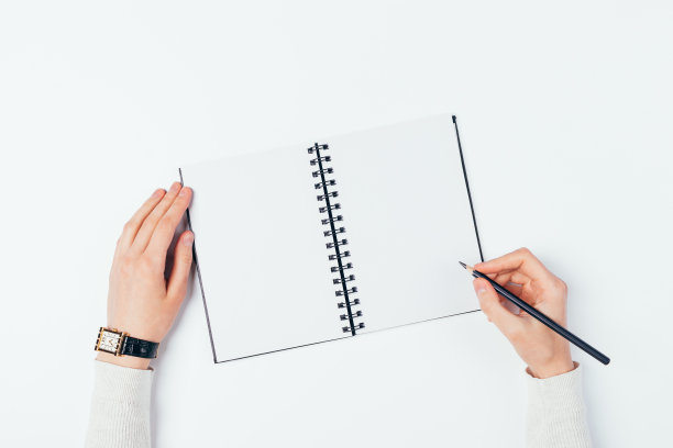俯视图女性的手写在一个空白笔记本上图片下载
