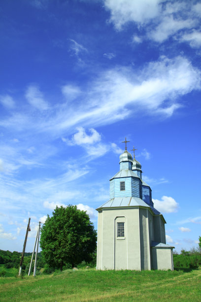 在村庄郊区的小山上有一座教堂。俄罗斯的基督教寺庙景观。库存图片背景图片下载