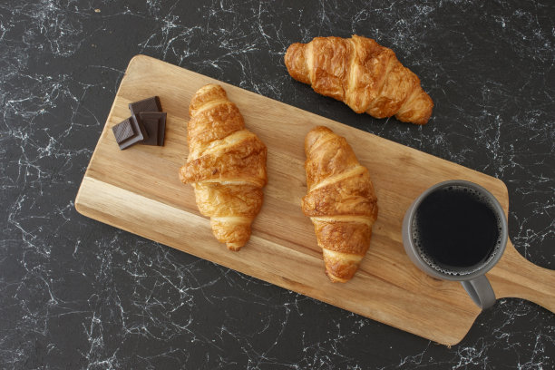 牛角面包和过滤咖啡放在木桌上，孤立的背景图片下载