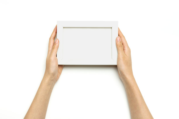 女人两手捧着一个白框孤立在白框上。图片下载